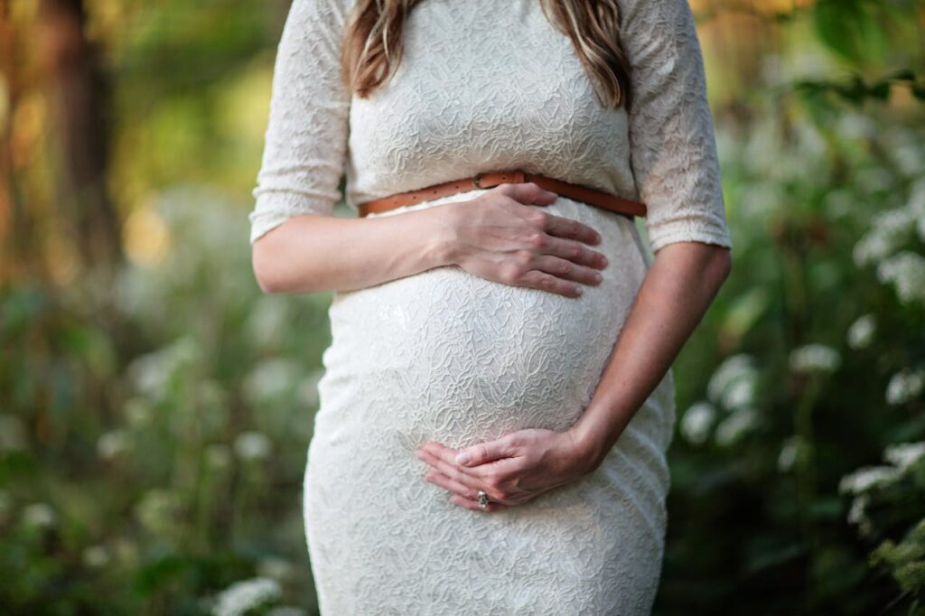 Uma mulher grávida alisando a barriga.