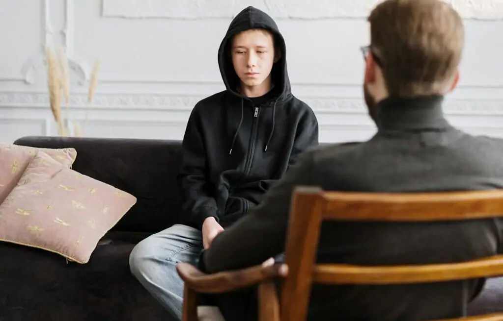 a imagem mostra um jovem com depressão em uma consulta com psiquiatra.