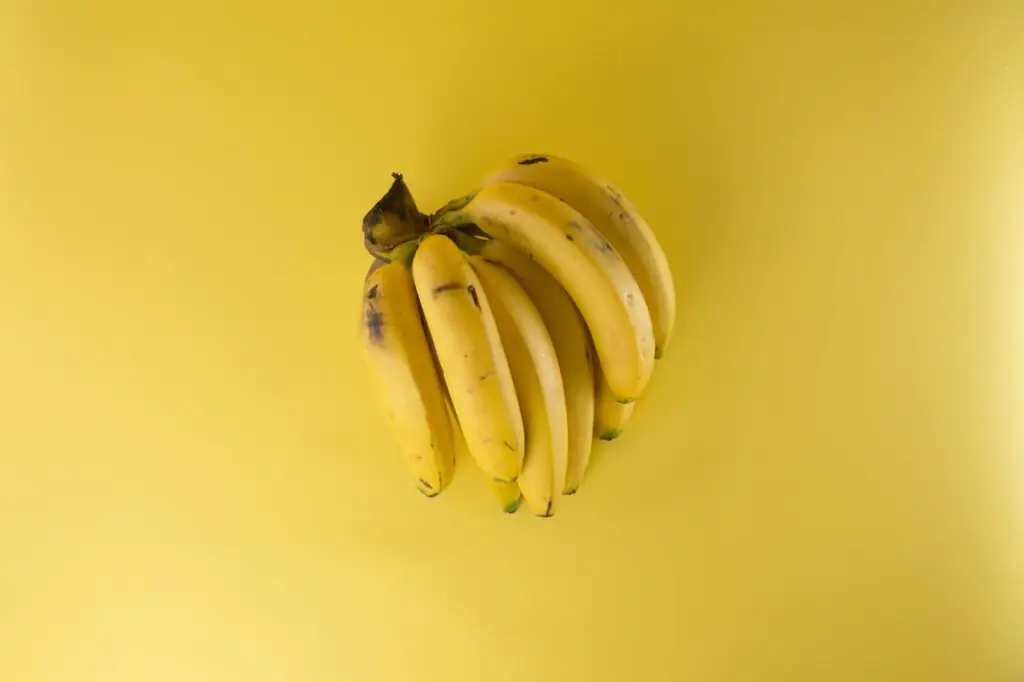 Um cacho de banana em um fundo amarelo.