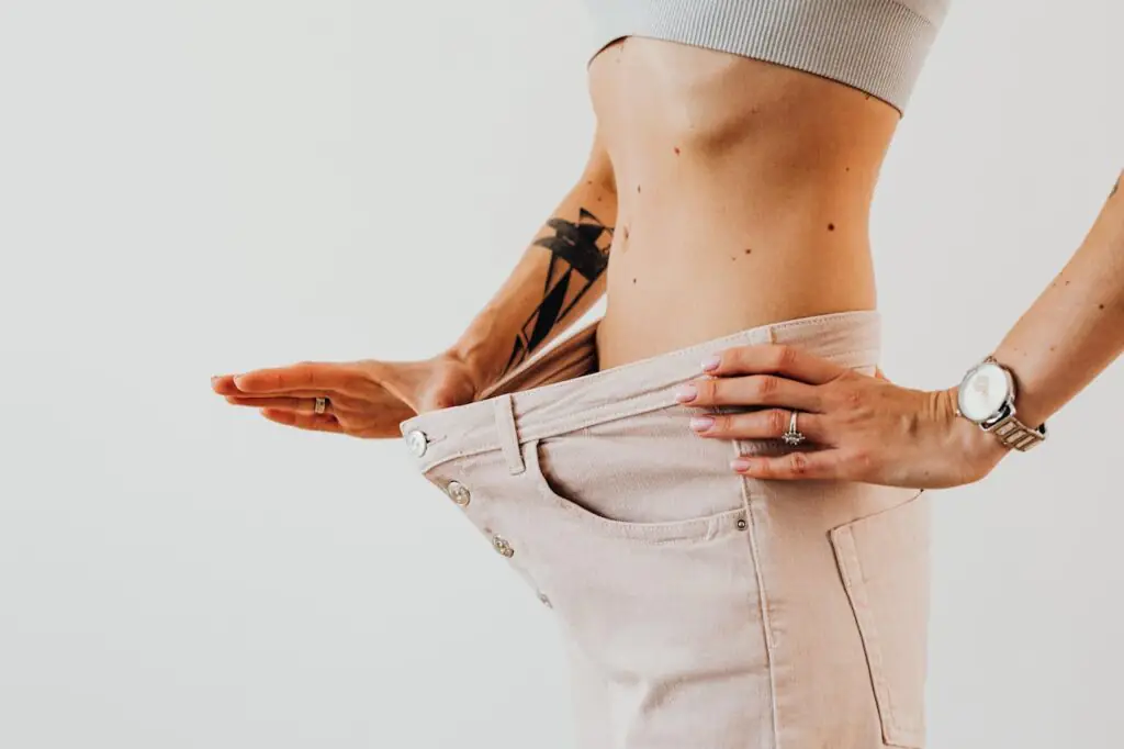 a imagem mostra uma mulher esticando a calça mostrando o quanto emagreceu.