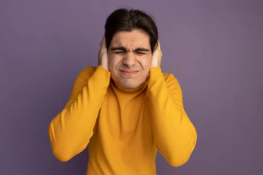 um homem sentindo uma forte dor no ouvido