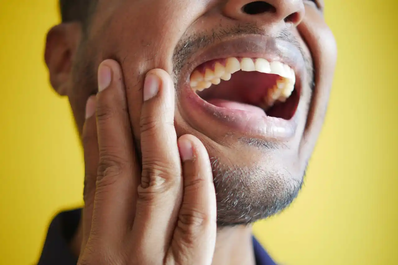 um homem sentindo dor de dente